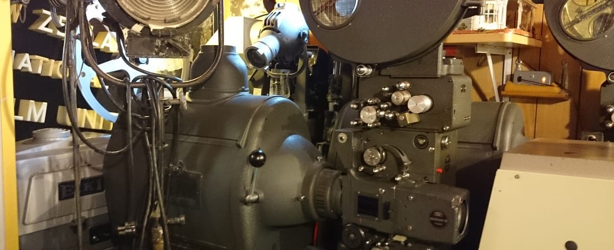 A picture of an old film projector; the projector itself is visible, along with part of a fresnel lens.